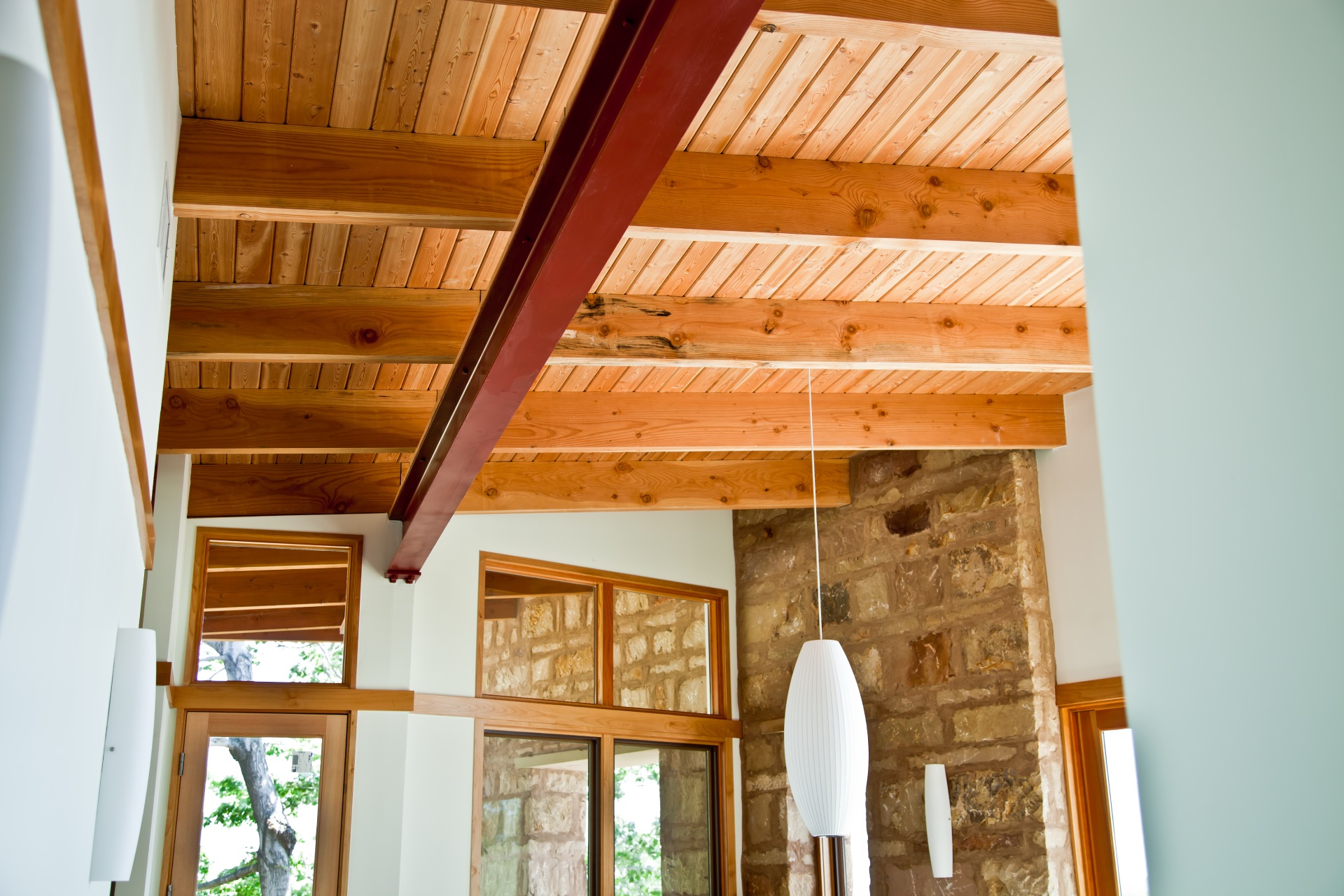 wooden ceiling with white chandelier hanging on it