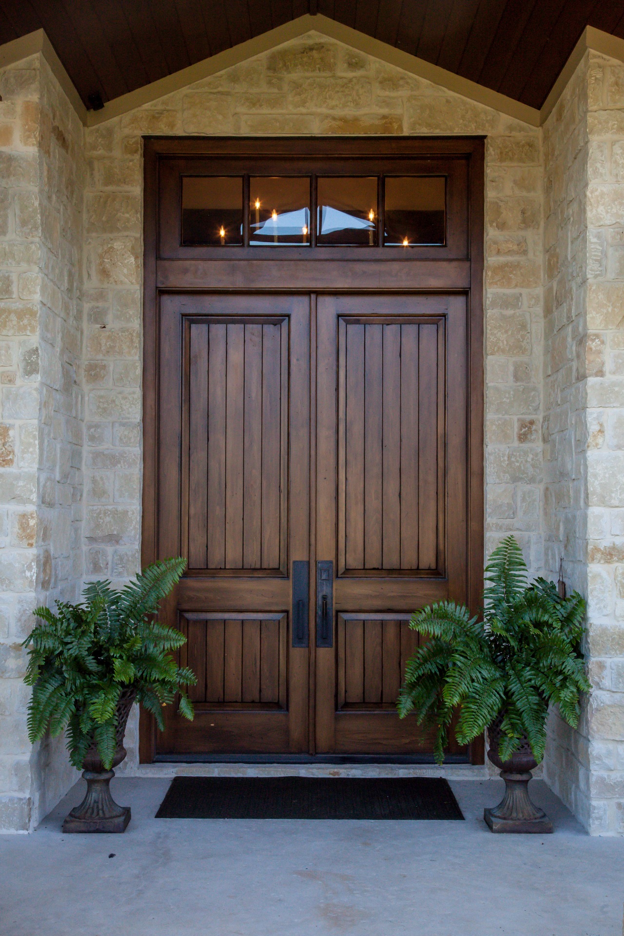 home entrance with brown door and two accent plants